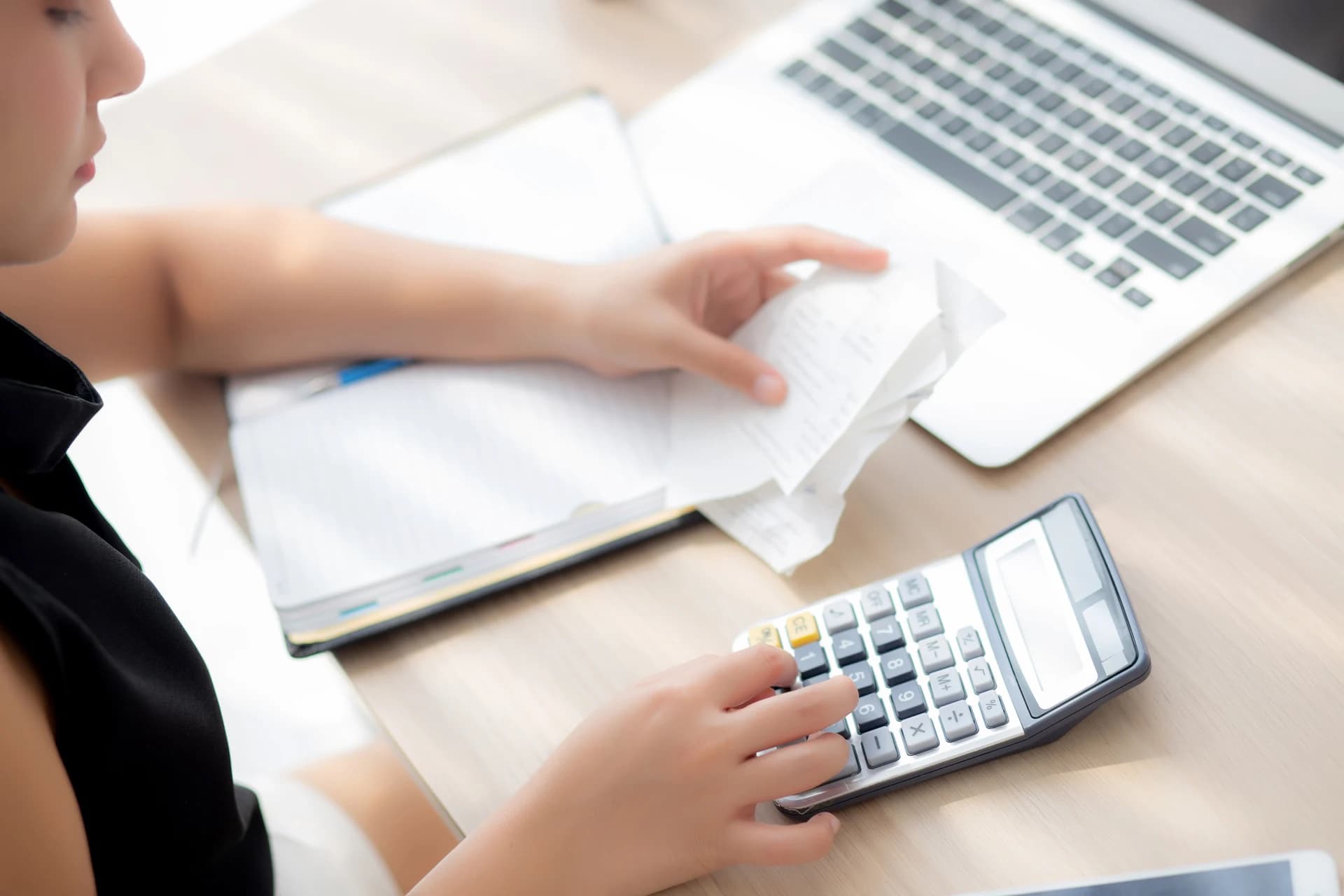 Mulher calculando cobranças e despesas com calculadora